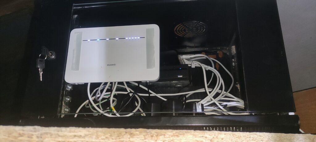 urządzenie sieciowe w szafce z nieuporządkowanym okablowaniem – przykład instalacji wymagającej modernizacji
