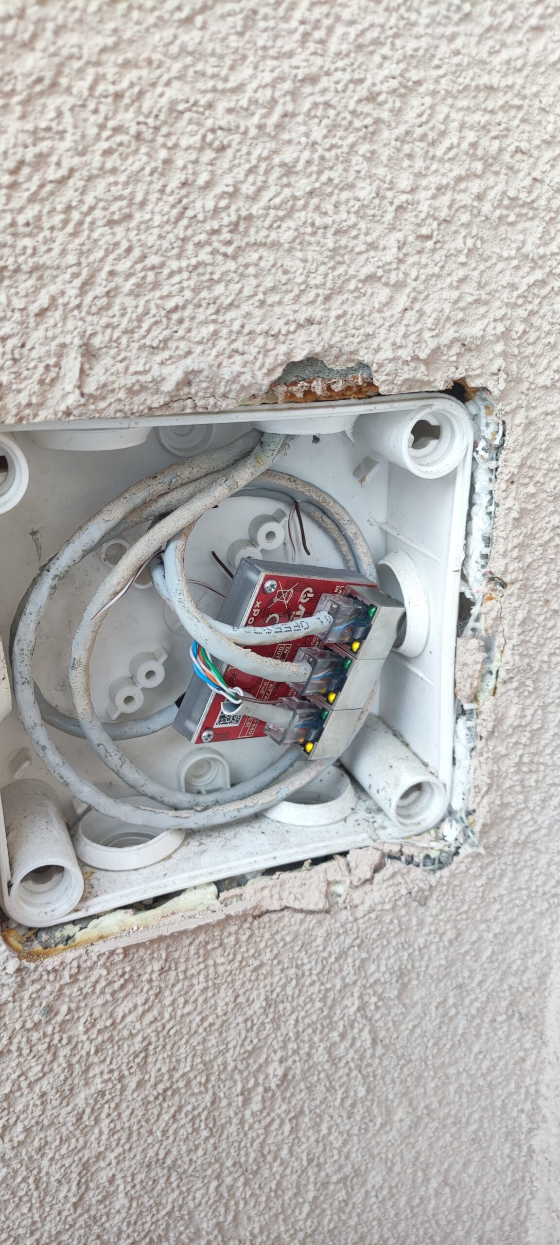 otwarta puszka elektryczna z przewodami w ścianie – przykład instalacji wymagającej oceny przed modernizacją